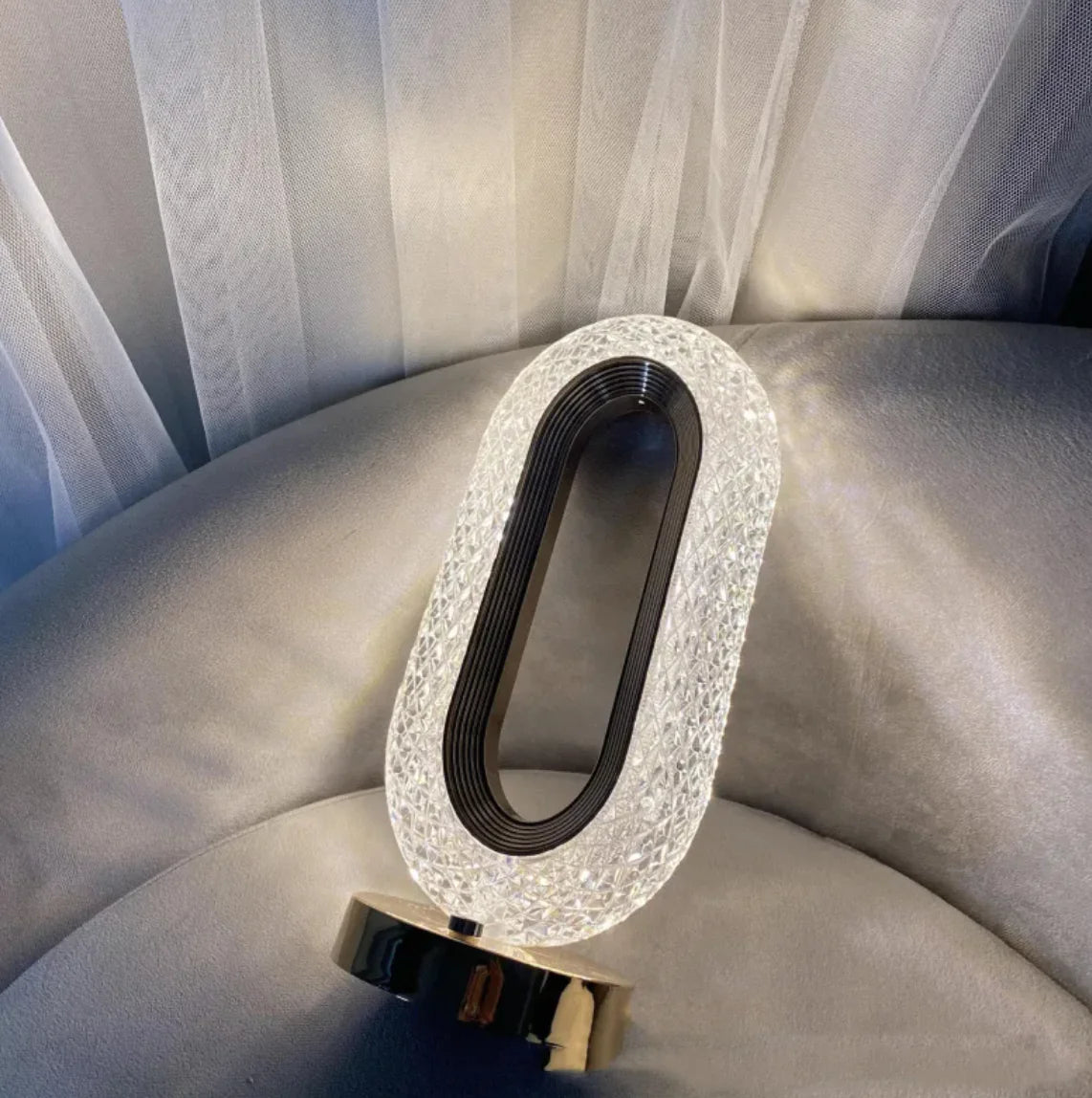 Crystal touch lamp shown from an angled side view with soft glowing light pattern on wall