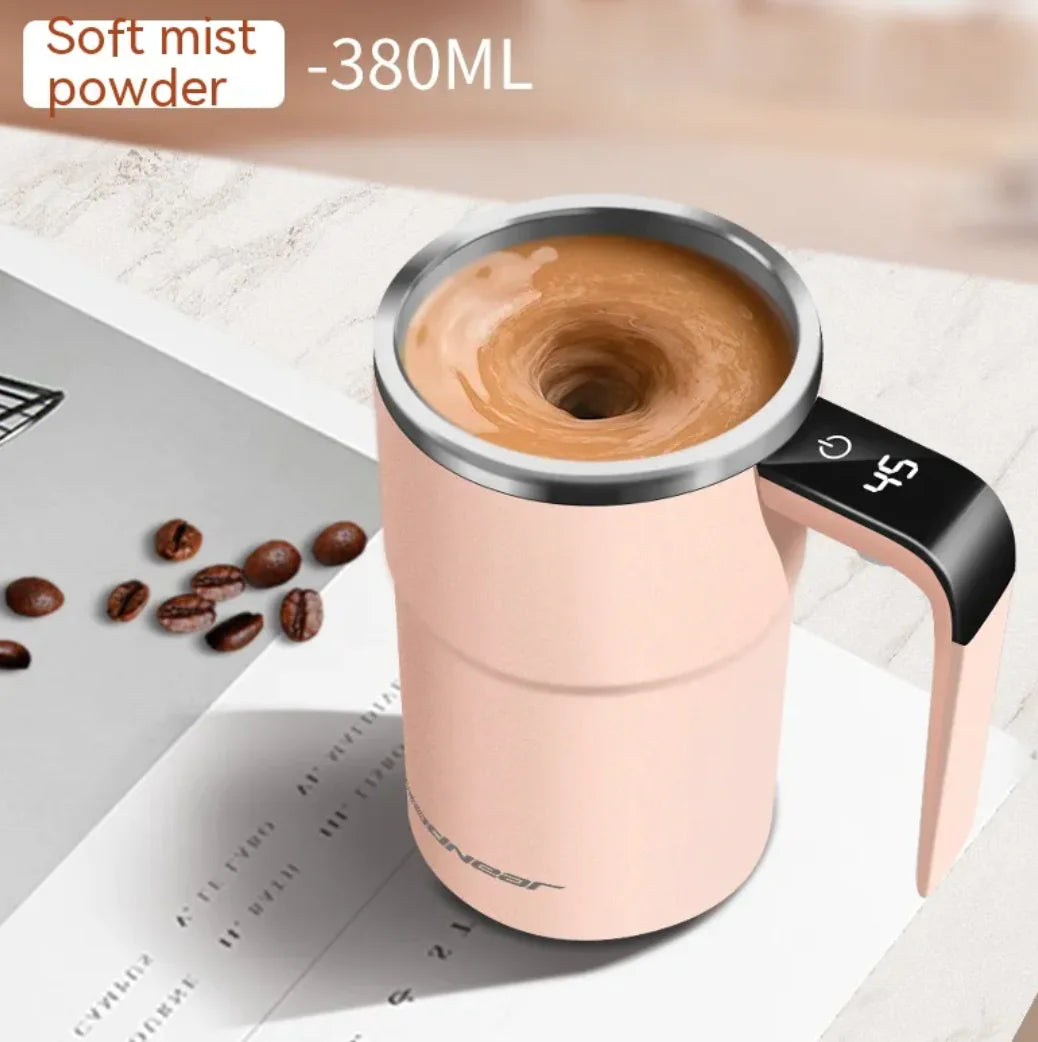 Pink 380ml smart self-stirring mug labeled Soft Mist Powder, with swirling coffee inside and coffee beans placed on a white surface