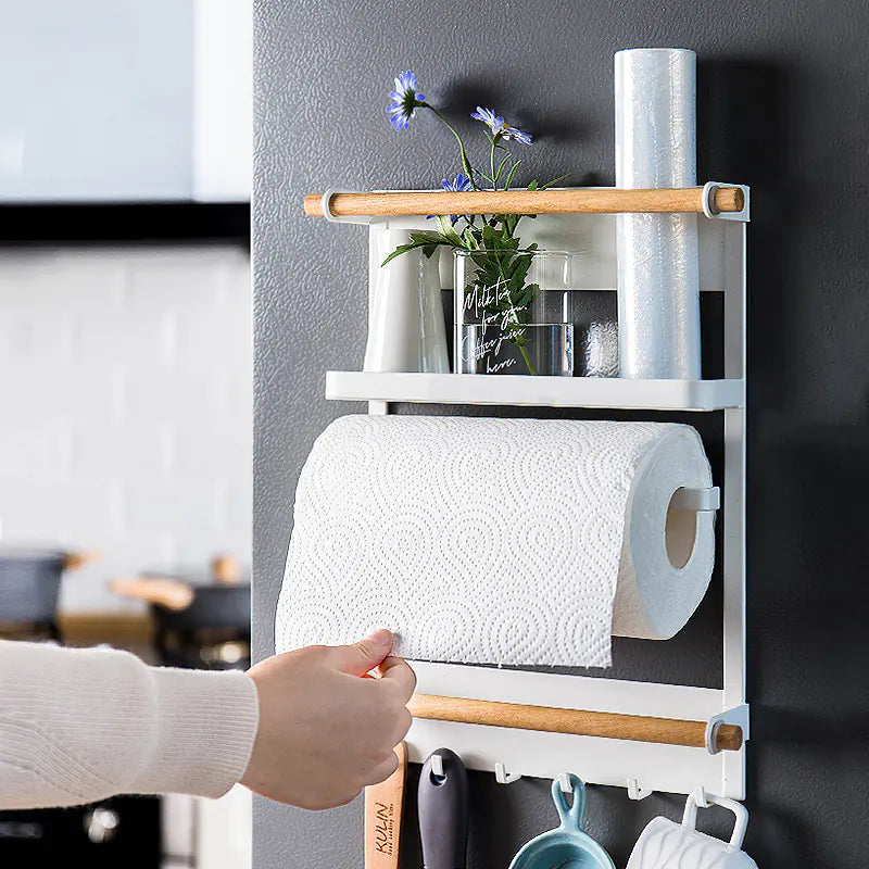 Wall-mounted kitchen storage rack with paper towel holder, hand pulling towel | Fixxora