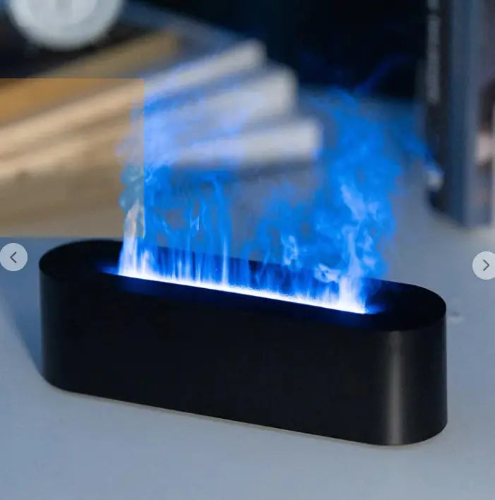 Black FlameGlow aroma diffuser releasing a vibrant blue flame-like mist on a desk setup.